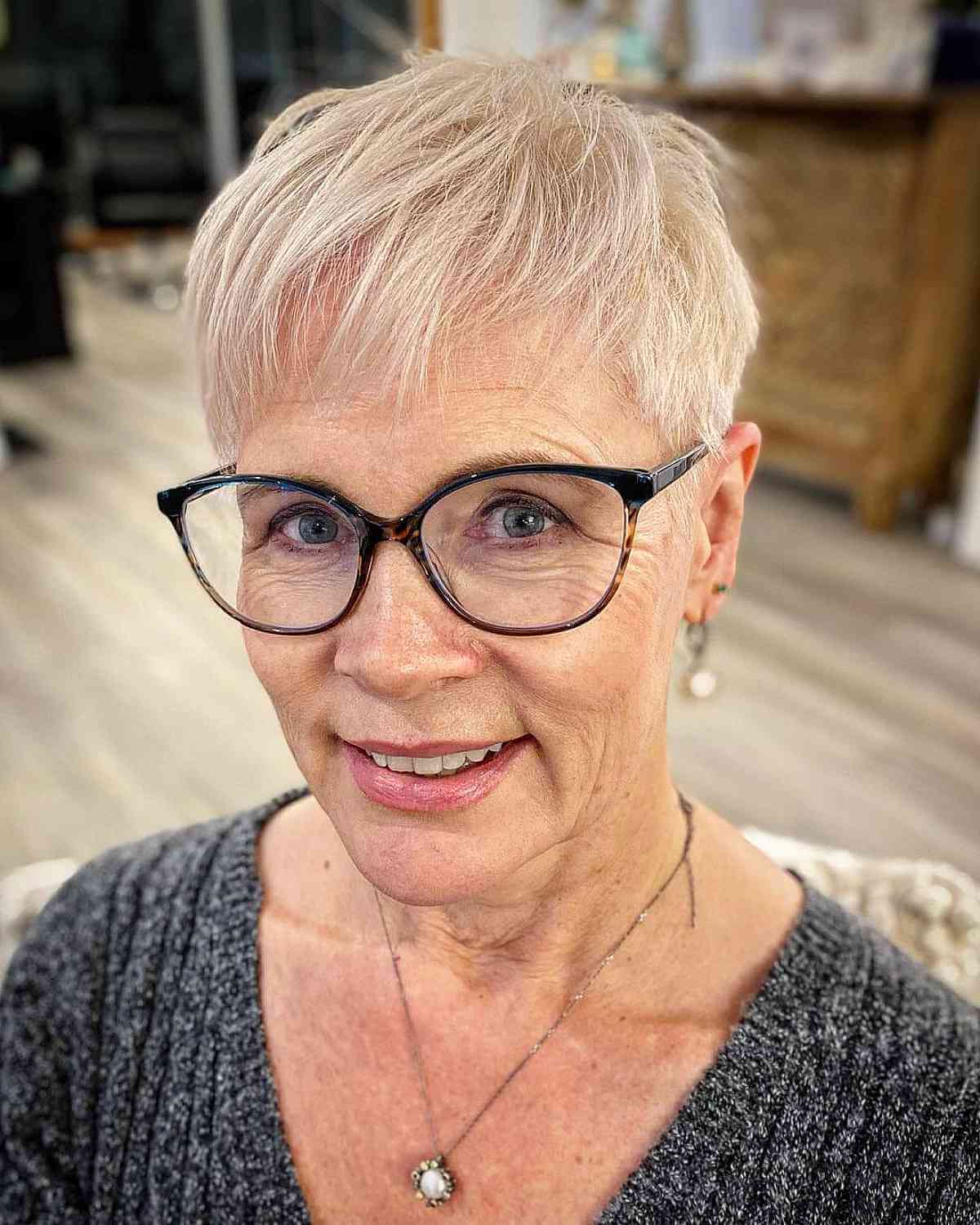 Younger looking pixie crop with bangs for women in their 50s with glasses