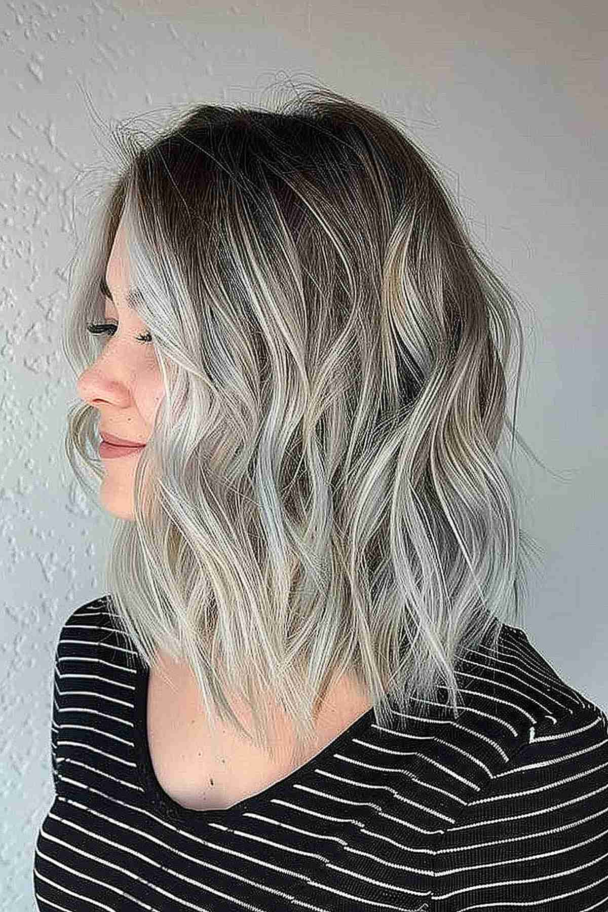 Medium-length wavy hair with a natural-looking silver ombre transition